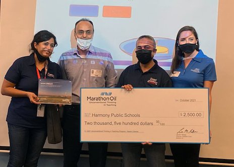 Harmony School of Innovation – Katy math teacher Nasim Chenari (far left) is awarded a check for $2,500 for her dedication to innovative education. She is joined by coworkers and staff from Marathon Oil which provided the grant award.